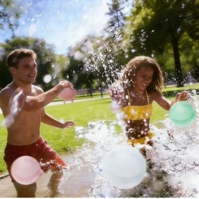 couple qui joue en plein air avec des ballons d’eau réutilisables