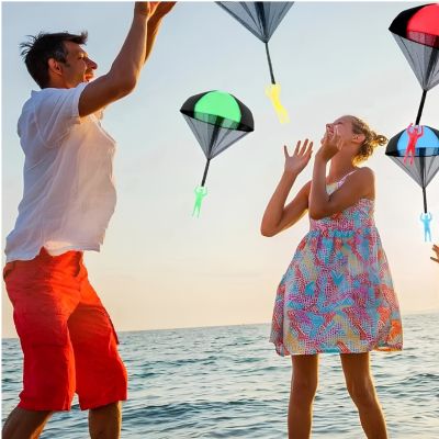 jeux extérieur parachute plage - deux enfants jouant avec parachutes colorés bord de mer