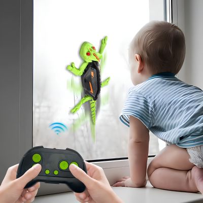 robot lézard télécommandé sur une vitre avec télécommande au premier plan 
