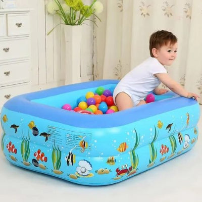 piscine gonflable bleue à motifs de poissons avec un enfant et des balles multicolores