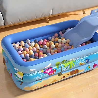 piscine gonflable bleue utilisée comme piscine à balles avec un petit toboggan