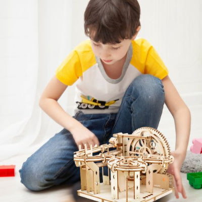 Puzzle en bois 3d enfant manipulant une maquette de circuit à billes en bois